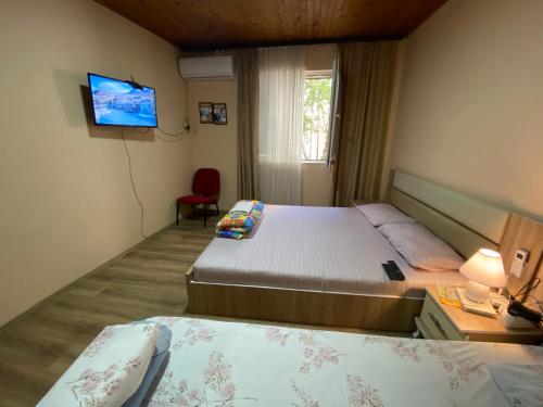 a hotel room with two beds and a television at ZANI Hostel in Prizren