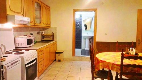 a kitchen with a table and a stove and a microwave at Villa Konaki in Grammatiko