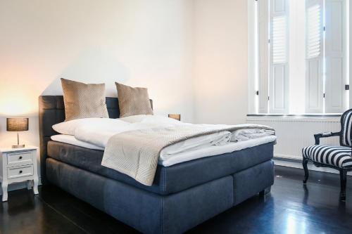 1 dormitorio con 1 cama y 1 silla en Mühlen-Apartment im Herrenhaus Rheinblick, en Xanten
