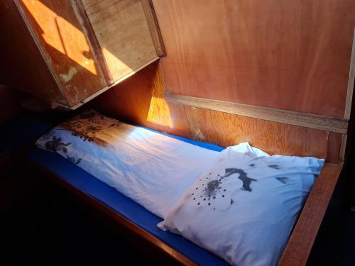 Cama en habitación pequeña con almohada en Anna Maria II en Ámsterdam