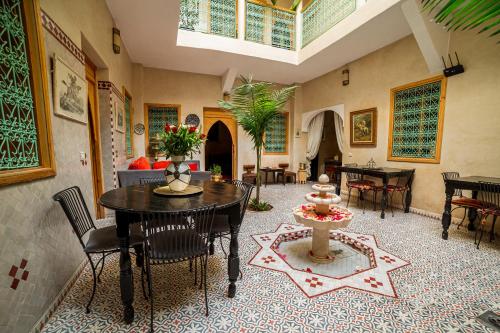 a living room with a table and chairs at Riad Inaka in Marrakech