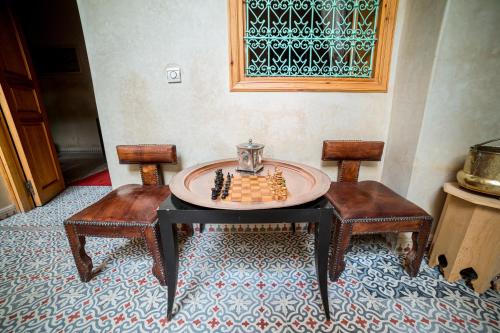 a table and two chairs with a chess board on it at Riad Inaka in Marrakech