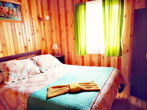 a bedroom with a bed with a towel on it at Cabañas Kompatzki in Ancud