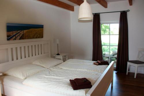 a bedroom with a large white bed and a window at Kleiner Feldblick in Hinrichsdorf