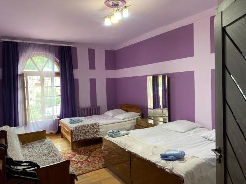 1 Schlafzimmer mit 2 Betten und einer lila Wand in der Unterkunft Areguni Guest House in Dilidschan