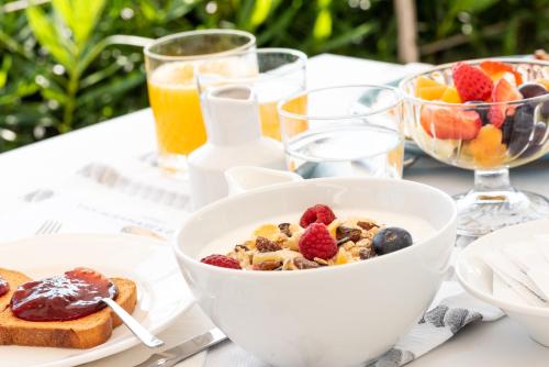 a table topped with a bowl of cereal and fruit at Hotels Vidi Miramare & Delfino in Lido di Jesolo
