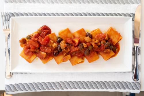a white plate of food with food on a table at Hotels Vidi Miramare & Delfino in Lido di Jesolo