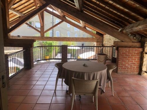 eine Terrasse mit einem Tisch und Stühlen auf dem Balkon in der Unterkunft Restaurant et Chambres d'Hôtes La Ferme de Cornadel in Anduze
