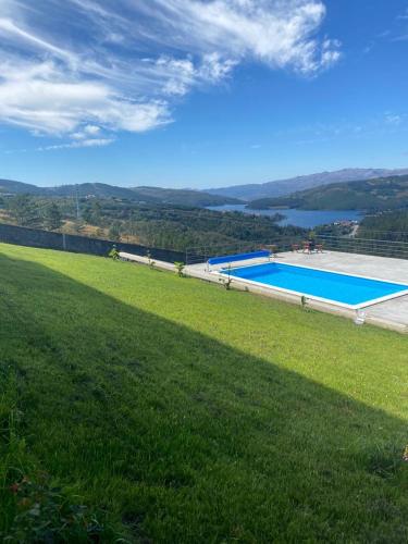 a large green field with a swimming pool at Vivenda das Carvalhas in Amiar