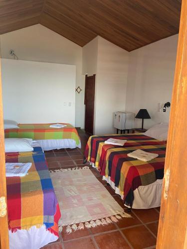 a bedroom with two beds with colorful blankets at WegoKite Stars in Taíba