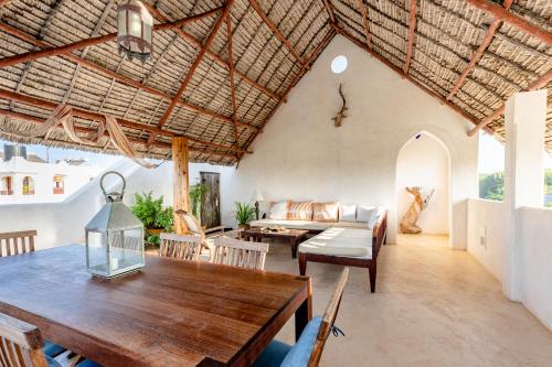 a living room filled with furniture and a table at Jua House in Lamu