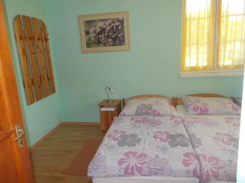 a bedroom with a bed and a dresser and two windows at Hétkanyar Vendégház in Nagyvázsony