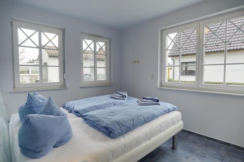 a bedroom with two beds and two windows at Villa Obendtied, FW 3 in Zingst
