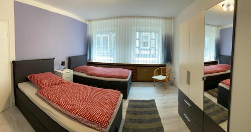 une chambre avec deux lits et une fenêtre dans l'établissement FeWo Villa - Mitten im Herz Goslar, à Goslar