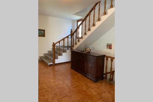 a hallway with stairs and a wooden cabinet in a house at Villa Anna Paola in Casal Palocco