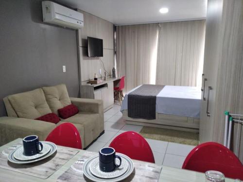een woonkamer met een bank en een bed in een kamer bij Estudio Confort West Flat com ótima localização. in Mossoró