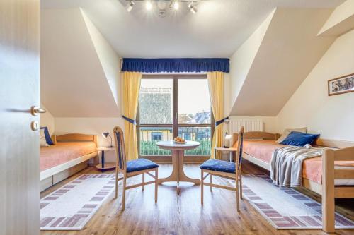 a bedroom with two beds and a table and chairs at Sommerwind Whg 3 in Zingst