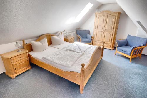 a bedroom with a bed and two blue chairs at Wittek, Birgit-Christin, Whg 8 in Zingst