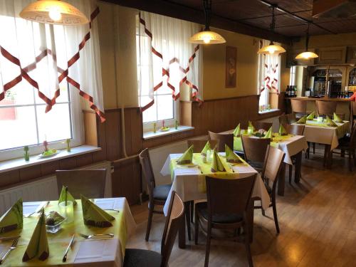 a dining room with tables and chairs and windows at Landgasthof Deinert in Parchen