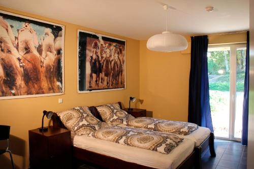 Bett in einem Zimmer mit Bildern an der Wand in der Unterkunft Mar-Halla in Friedenstal