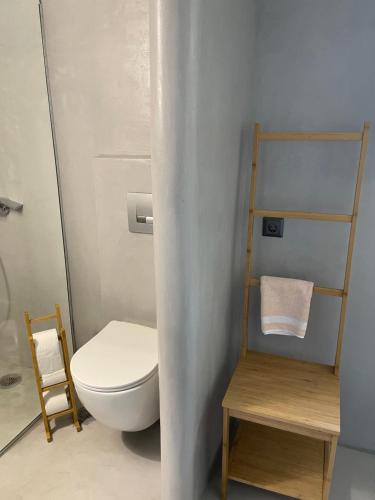 a bathroom with a toilet and a towel rack at Rania Apartments Sea View in Mýkonos City