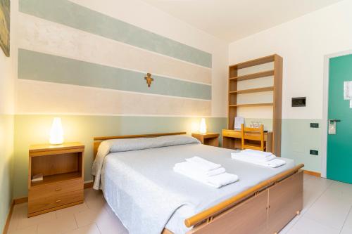 a bedroom with a bed with a cross on the wall at Il Seminario in Alba