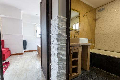 ein Badezimmer mit einer Badewanne und einem Waschbecken in der Unterkunft ApartKhozama in Camet Norte
