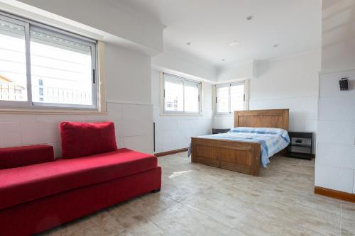 ein Schlafzimmer mit einem Bett und einem roten Sofa in der Unterkunft ApartKhozama in Camet Norte