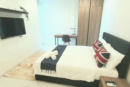 a bedroom with a bed and a desk and a television at Kozi Square New Apartment Cozy Home 9A in Kuching