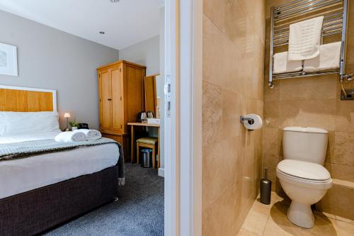 a bedroom with a bed and a bathroom with a toilet at The Golden Lion, Newport, PEMBROKESHIRE in Newport