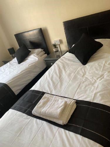 two beds in a hotel room with a towel on them at Burlington Hotel in Sandown