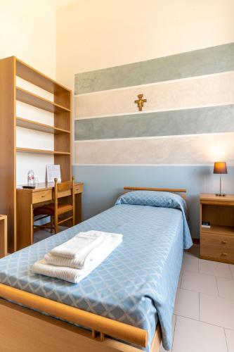a bedroom with a blue bed and a desk at Il Seminario in Alba