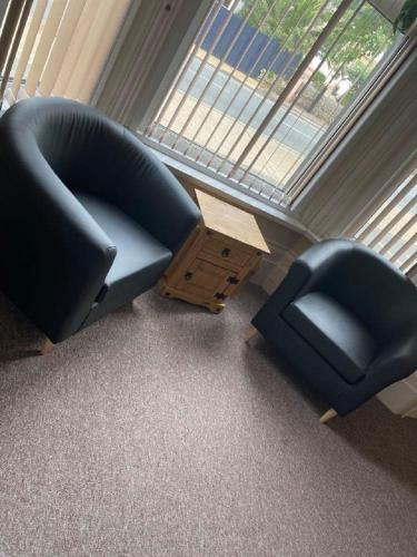 a living room with two chairs and a table at Burlington Hotel in Sandown