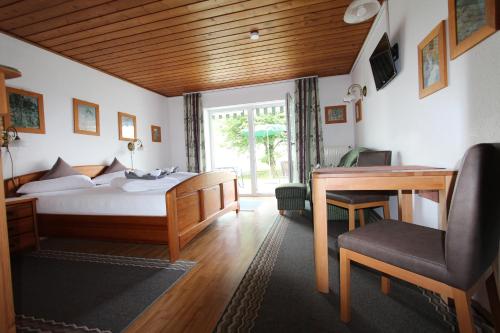 Aparthotel Naturidyll - Wieserhof في باد فسينغ: غرفة نوم بسرير ومكتب وطاولة