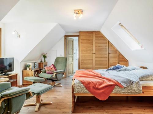 a bedroom with a bed and chairs in a attic at Seenest Appartement 3 in Zingst