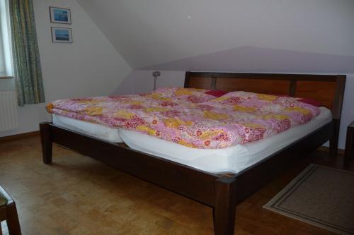 Una cama con una manta rosa y amarilla. en Fewo 2 "Landhaus am Grashof" en Offenbüttel