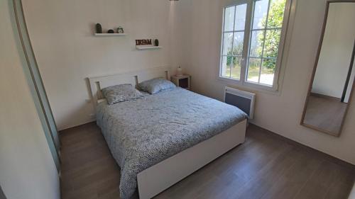 1 dormitorio con cama y ventana grande en Maison 400m Océan avec jardin clos et ombragé, en Saint-Georges-dʼOléron