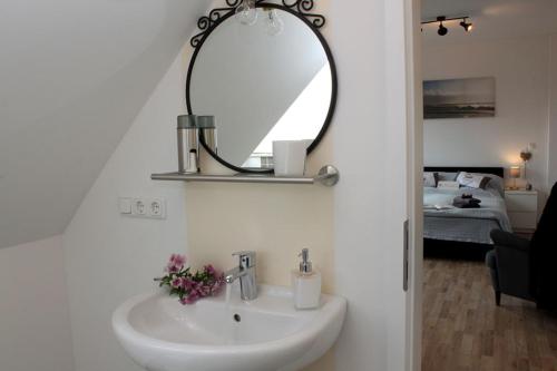 a bathroom with a white sink and a mirror at Ferienzimmer 2 Engelmann-Beck in Eitzen Zwei