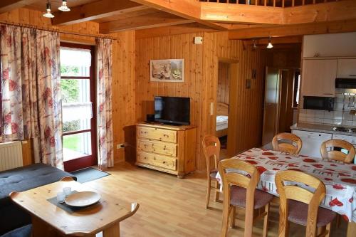 une chambre avec une table, une cuisine et une salle à manger dans l'établissement Ferienhaus Nr 10A2, Feriendorf Hagbügerl, Bayr Wald, à Waldmünchen