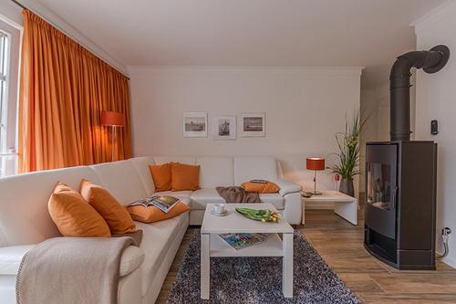 a living room with a white couch and a fireplace at Les Belles, Haus Bastien, FW Charmant, Whg 7 in Zingst
