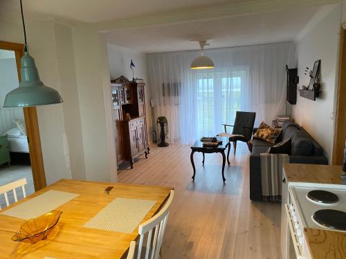 a kitchen and living room with a wooden table at Gamla Húsið - The Old House in Selfoss