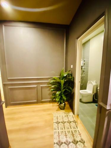 a bathroom with a toilet and a potted plant at Faizal Madhi Homestay in Kuching
