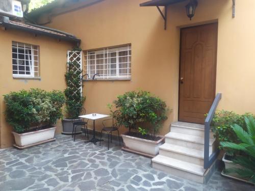 a house with a door and a table and some plants at Le Stanze Apartament in Bologna