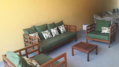 ein Wohnzimmer mit einem grünen Sofa und 2 Stühlen in der Unterkunft RECANTO DE ZEZE in Ilhéus