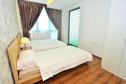 een slaapkamer met 2 bedden en een raam bij Vivacity Jazz Suite New Luxury Cozy Home A13 in Kuching