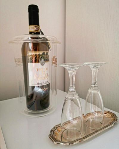 Una botella de vino y dos copas en una mesa en Feudo di Castelmozzo, en Santa Paolina