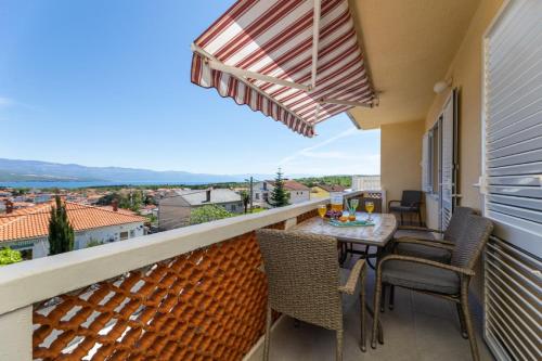 a balcony with a table and chairs and a view at Apartman Gržetić in Šilo