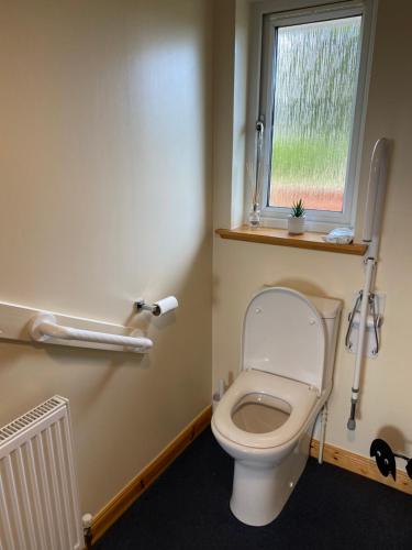 La salle de bains est pourvue de toilettes et d'une fenêtre. dans l'établissement Tigh Murdag, 37D Newmarket HS2 0DT, à Stornoway