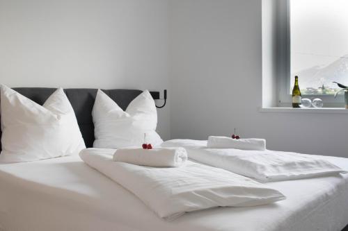 2 weiße Betten mit weißen Kissen und einem Fenster in der Unterkunft CasaLuNa in Appiano sulla Strada del Vino