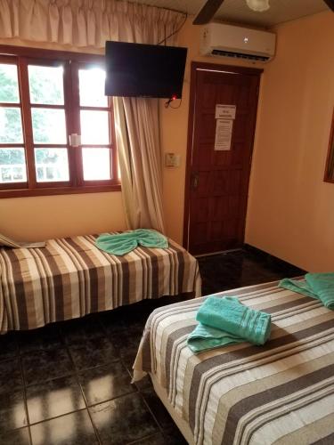 a room with two beds and a window at Hotel AATRAC Iguazú in Puerto Iguazú